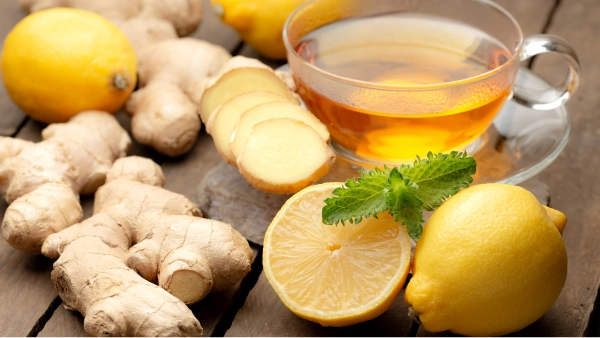 Une tasse de thé, du citron et du gingembre sur une table.